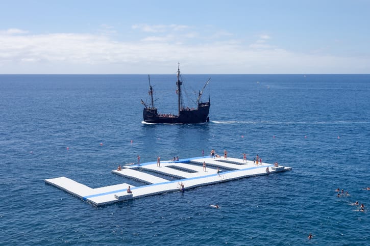 A large outdoor pool by the sea, illustrative of a luxury swimming lagoon